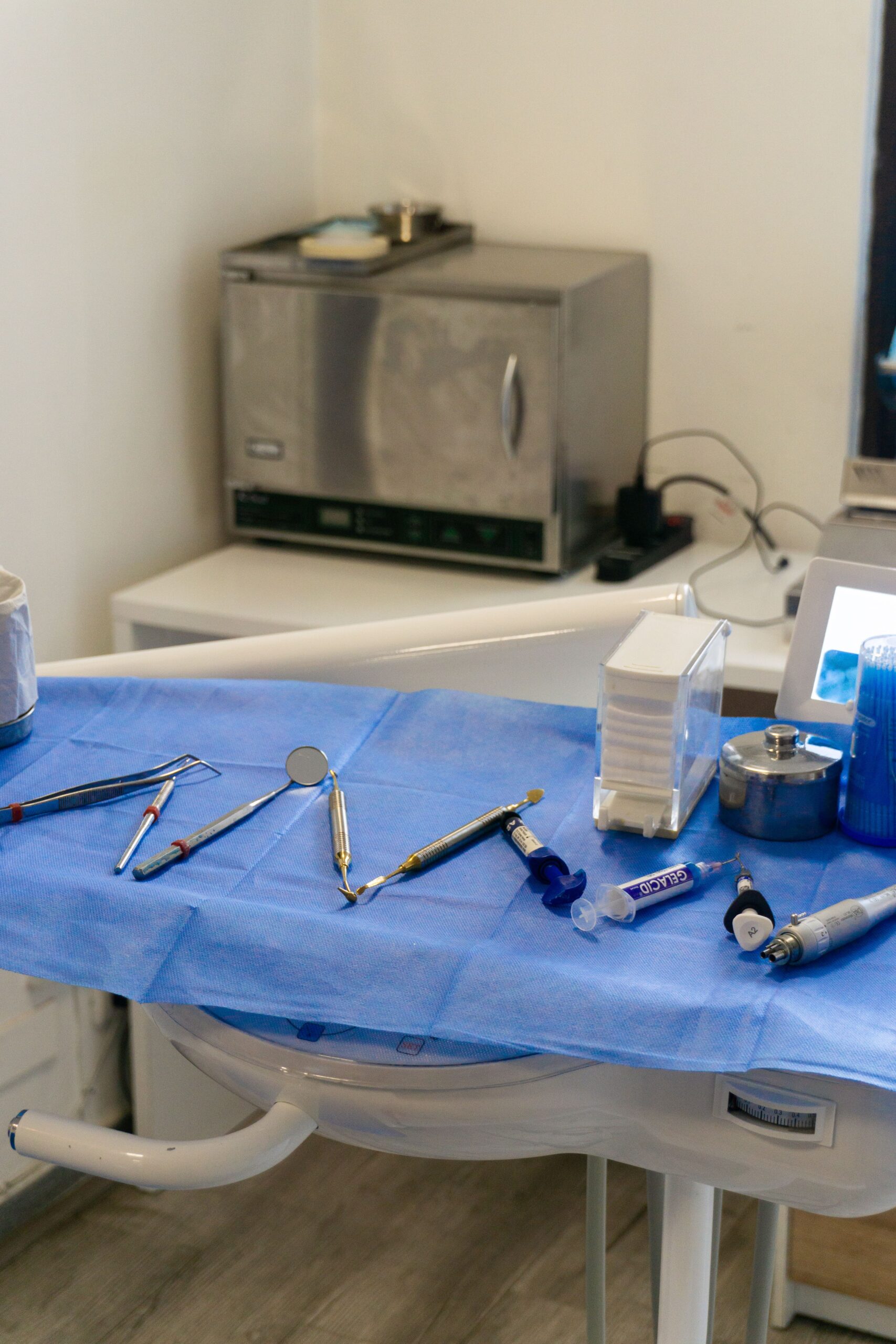 A brightly lit dental office with instruments laid out on a tray, ready for use.